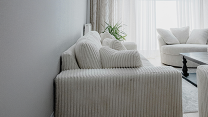 White upholstered sofas and armchairs in a bright room